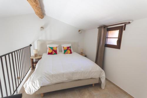 a bedroom with a bed and a window at Le Baguier in La Roquebrussanne