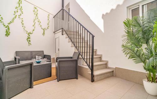 a staircase in a living room with chairs and a table at Two-Bedroom Stunning Home In El Gastor in El Gastor