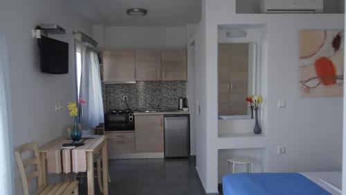 a kitchen with a small table and a kitchen with a counter at Zathea Apartments in Agia Pelagia Kythira