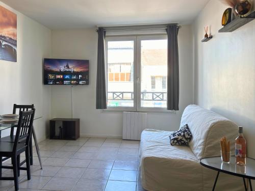 a living room with a couch and a table at Vaillant - Tout confort - Fibre - 5min du Tramway #SirDest in Bezons