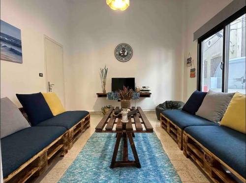 a living room with two blue couches and a table at Nassma guesthouse in Anfah