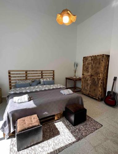 a bedroom with a large bed and a guitar at Nassma guesthouse in Anfah