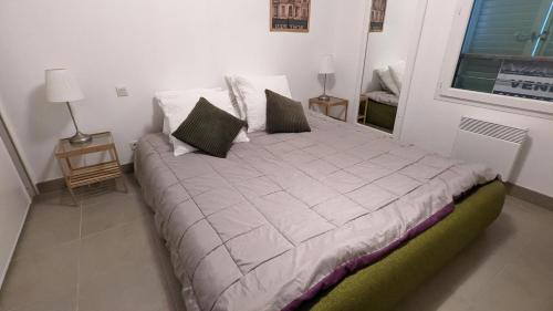 une chambre avec un grand lit avec deux oreillers dans l'établissement Appartement Rive Nature coté parc et rivière, à Saint-Raphaël