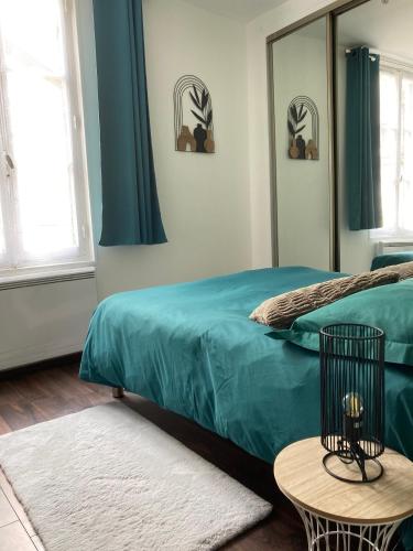 - une chambre avec un lit vert et un miroir dans l'établissement Joli appart F2, les 3 croissants, centre ville, à Sens