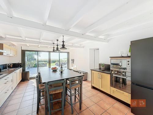 une grande cuisine avec une table et des chaises. dans l'établissement Les portes du golf Wimereux - Face mer, à Wimereux