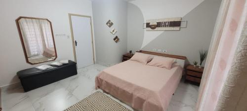 a small bedroom with a bed and a mirror at APTO DUPLEX 3 Dorm em APARECIDA 600 m da basilica in Aparecida