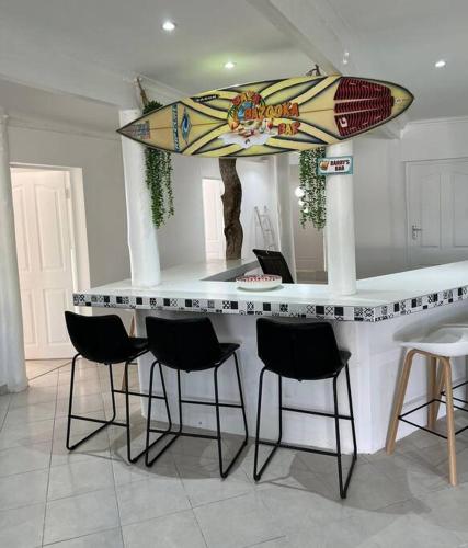 a counter with chairs and a surfboard on top of it at Sunset Villa 44 in Mateus