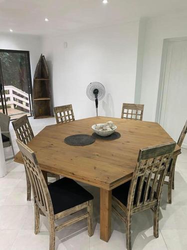 a wooden table with chairs and a bowl of food on it at Sunset Villa 44 in Mateus