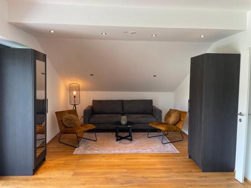 a living room with a couch and two chairs at EuroParcs Wörthersee in Schiefling am See