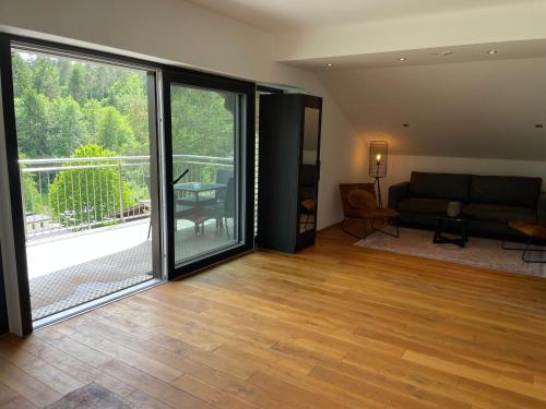 a living room with a couch and sliding glass doors at EuroParcs Wörthersee in Schiefling am See
