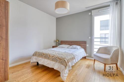 une chambre avec un lit, une chaise et une fenêtre dans l'établissement Le Spacieux - En bordure de Paris - 366B, à Issy-les-Moulineaux