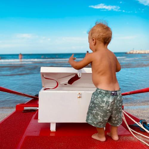 a young child standing on a boat at the beach at Hotel Franca in Milano Marittima