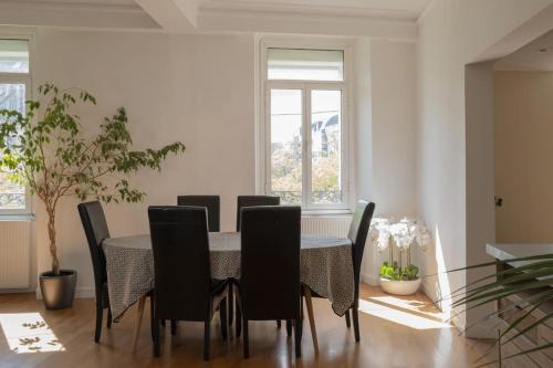 une salle à manger avec une table et des chaises noires dans l'établissement Cholet, en Centre-Ville et Spacieux, Proche du Parc du Puy DuFou, à Cholet