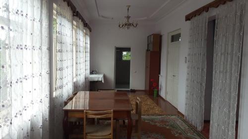 a dining room with a wooden table in a room at სახლი ბუნებაში House in nature in Tsikhisdziri