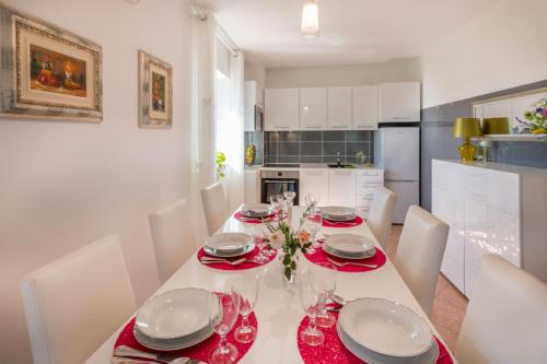 a dining room with a table and chairs and a kitchen at Villa Ida, a charming villa in a rustic setting in Potpićan