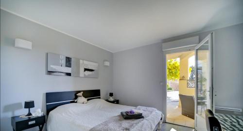 une chambre avec un lit et une porte coulissante en verre dans l'établissement VILLA SUPERBE VUE MER SUR LA BAIE DE BANDOL , 200 m des PLAGES, à Sanary-sur-Mer