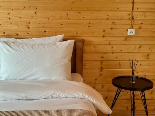 a bed with white pillows and a table in a room at Rakursi in Jut'a