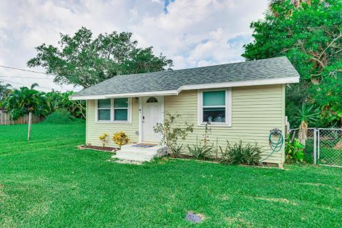 a small yellow house with a grass yard at Centrally Located Merritt Island Cottage with Deck! in Merritt Island