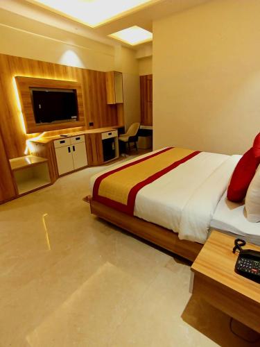 a bedroom with a bed and a desk and a television at Masaga by Qcent, Gurugram in Gurgaon
