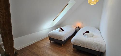 two twin beds in a room with white walls at Gîte L'Ostau 4 étoiles Les Échappées Belles in Antignac