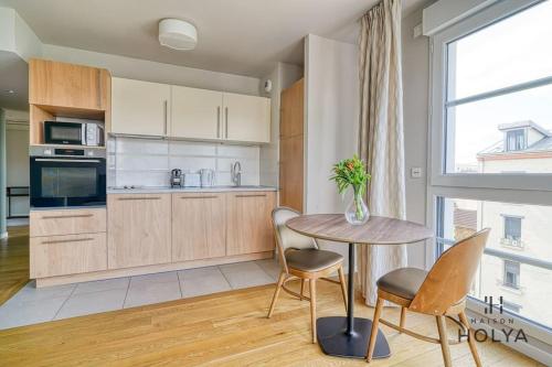 une cuisine avec une table et des chaises et une fenêtre dans l'établissement Le Panorama - À deux pas de Paris - 367B, à Issy-les-Moulineaux