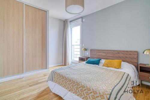 une chambre avec un lit et une grande fenêtre dans l'établissement Le Panorama - À deux pas de Paris - 367B, à Issy-les-Moulineaux