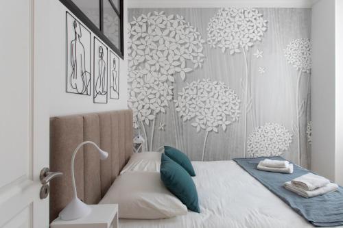 - une chambre avec un lit orné de fleurs sur le mur dans l'établissement L52 2BDR Massena central, 2 min from the beach AC, à Nice