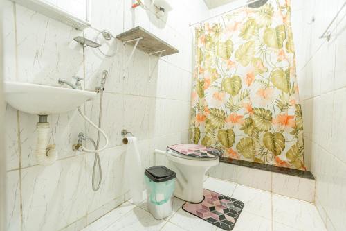 a bathroom with a toilet and a sink and a shower curtain at Casa com WiFi em Morro do Moreno, Angra dos Reis in Angra dos Reis