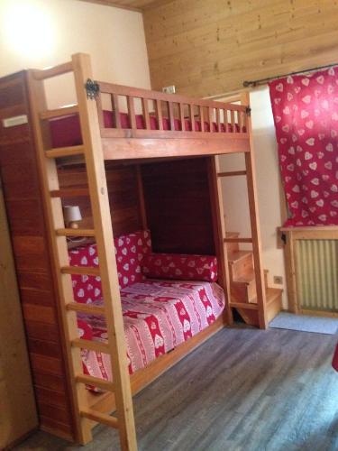 drewnianym łóżkiem piętrowym z małym łóżkiem w pokoju w obiekcie Spacieux Studio - Les chaudes Almes w mieście Tignes