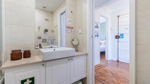 a white bathroom with a sink and a hallway at Charming Belém 3BDR Property by LovelyStay in Lisbon