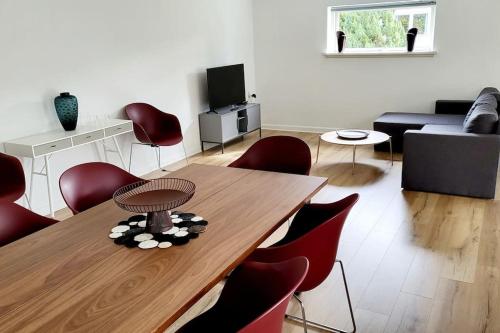 a living room with a wooden table and red chairs at Billund Centre Rica House,500m to Lego House in Billund