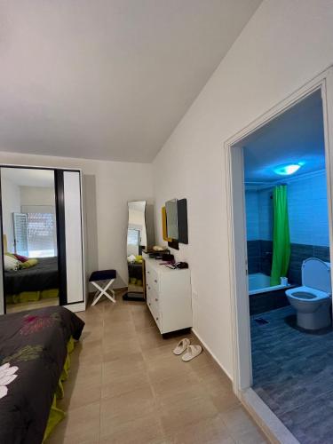 ein Schlafzimmer mit einem Bett und einem TV sowie ein Badezimmer in der Unterkunft Ehden apartment - Beyond borders guesthouse in Ehden