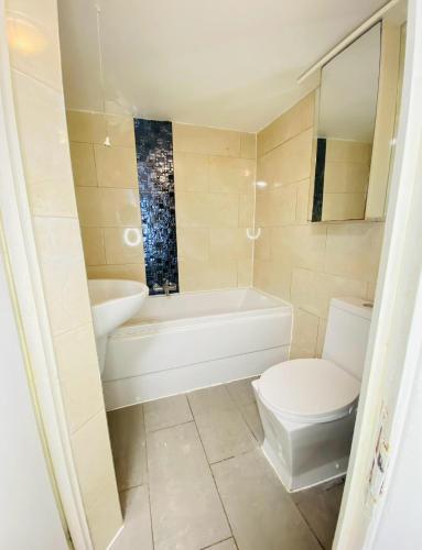 a bathroom with a tub and a toilet and a sink at London Stays Whitechapel in London