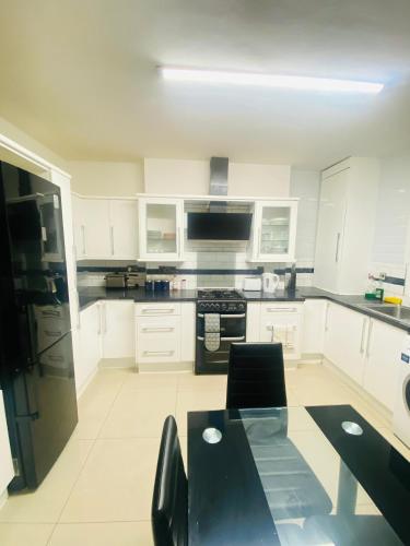 a kitchen with white cabinets and a black table at London Stays Whitechapel in London