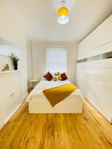 a bedroom with a white bed and wooden floors at London Stays Whitechapel in London