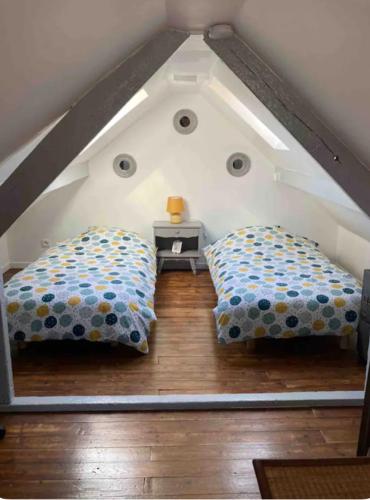 - deux oreillers installés au sol dans un grenier dans l'établissement Maison de vacances bord de mer à Lion sur Mer, à Lion-sur-Mer