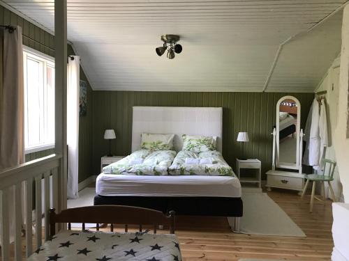 a bedroom with a large bed with green walls at Little Red School House in Töfsala