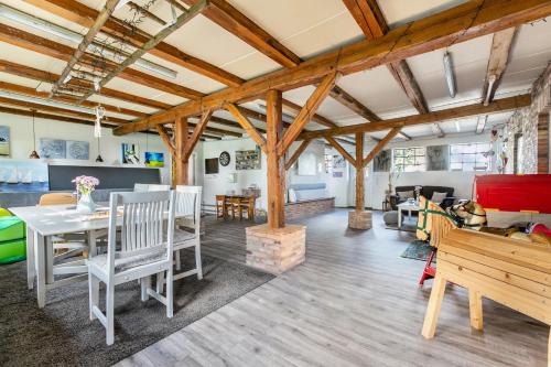 a living room with wooden ceilings and a table and chairs at Ferienwohnung Hof Krakebüll in Humptrup