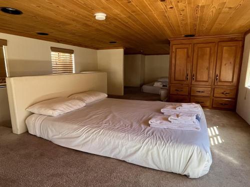 a large bed in a room with a wooden ceiling at Cabin 41 in Almont