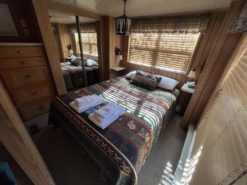a small bedroom with a bed and a mirror at Cabin 61 in Almont