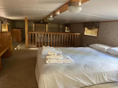 a bedroom with a bed with towels on it at Cabin 63 in Almont