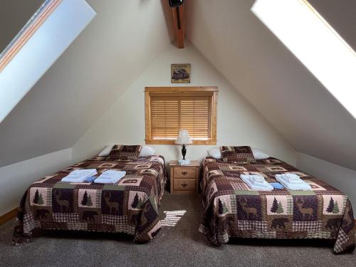 a attic bedroom with two beds and a window at Cabin 28 in Almont
