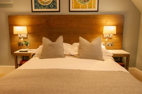 a bedroom with a large bed with pillows and two lamps at The Georgian, Haslemere, Surrey in Haslemere