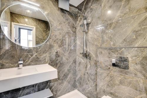 une salle de bain avec un lavabo et un miroir dans l'établissement Pick A Flat's Apartments in Montmartre - Rue des Cottages, à Paris