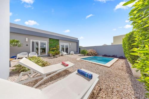 a patio with white chairs and a swimming pool at Luxury 1br Getaway Wpool In Washington By Lucha in Palm-Eagle Beach