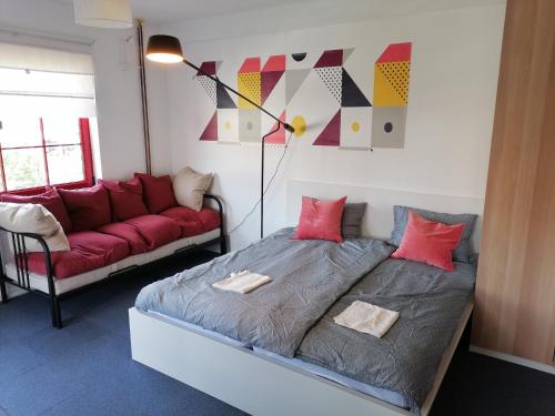 a bedroom with a bed and a red couch at OFOO Zagreb in Zagreb