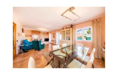 a living room with a glass table and chairs at Villa Malens in Llucmajor