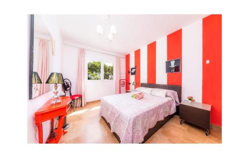 a bedroom with red and white striped walls and a bed at Villa Malens in Llucmajor