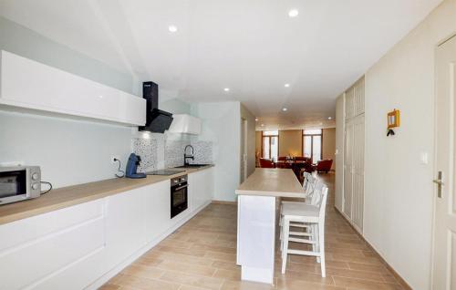 une cuisine avec des armoires blanches et un comptoir dans l'établissement Cozy Home In Saint-Génis-Des-Fontaines, à Saint-Génis