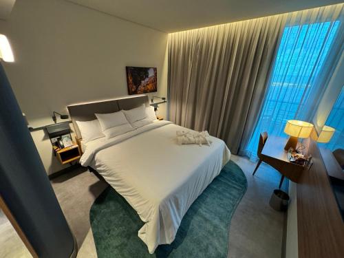 a bedroom with a large white bed and windows at Novotel Recife Marina in Recife